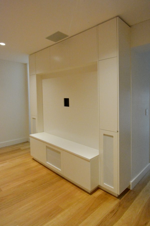 Custom made Entertainment unit Potts Point. Poly painted in vivid white with built-in speakers and sub. Custom made joinery and cabinet making.