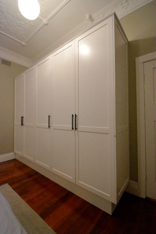 KIRRIBILL SHAKER STYLE WARDROBE. A shaker-style wardrobe finished in white poly paint with matt black handles for contrast. This customer was replacing an old wardrobe after they had moved into a new unit. We used pull-down hanging rails for easy access to their clothes as the wardrobe is 2.4m high and all Blum hinges and draws runner to last.
