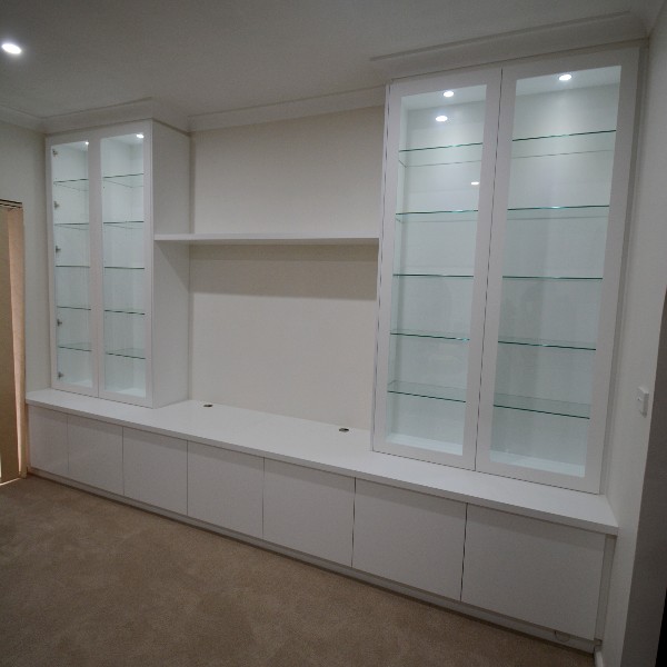 Custom-made entertainment unit in Hornsby. Poly painted in vivid white. This Was made for a customer who wants to display his collection of navy memorabilia. All with soft close, push touch glass doors and led down lights.