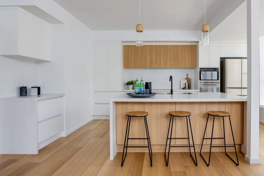 A custom made bespoke white modern kitchen with white oak details