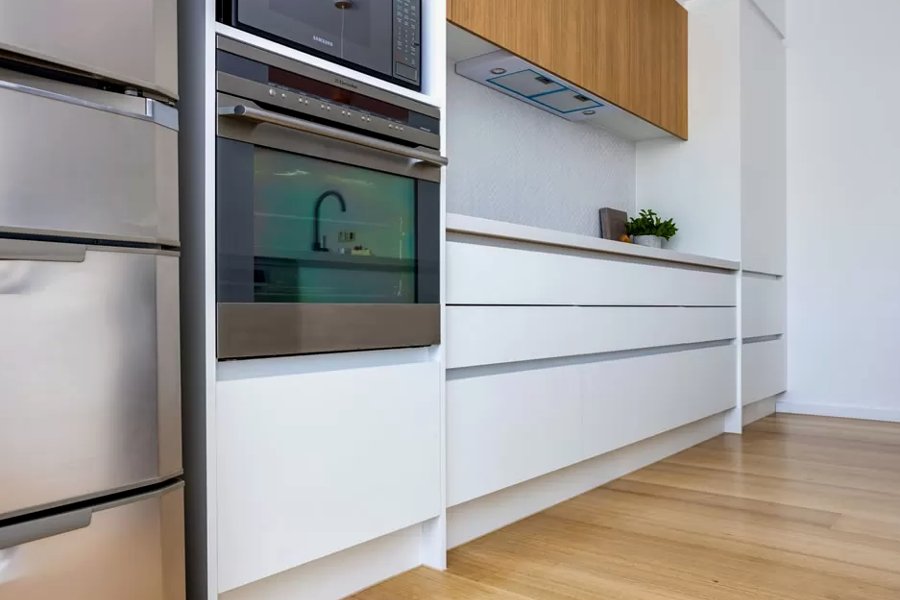 A custom made bespoke white modern kitchen with white oak details